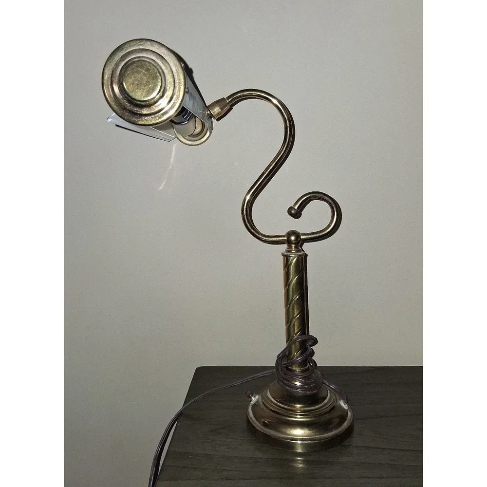 Vintage brass tone desk lamp with elegant scroll arm and classic piano light